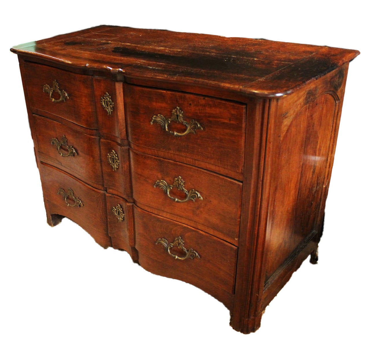 Dark walnut serpentine carved commode with four drawers, original handcrafted ormolu and escutcheons, circa 18th century, France.