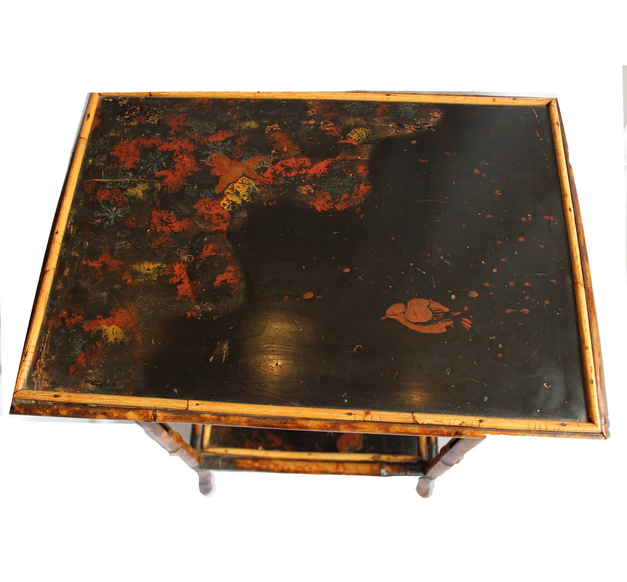 Bamboo side table that can be used as a tea cart, occasional table, or drinks table, depicts flora and fauna in painted scene on top and base.  Late 19th century, England.