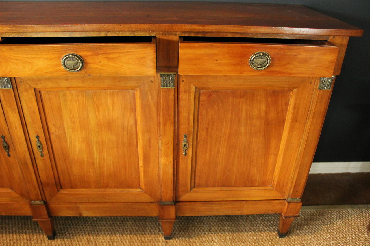 Enfilade with clean lines and a fresh approach, this early 20th century French walnut enfilade embraces old and new with style. Features three cabinet doors, three drawers, original brass fittings, keys, escutcheons and drawer pulls.