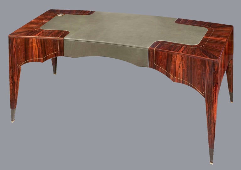 Antoine's brass-inlaid skirt desk is a study in exquisitely considered and finished wood furniture. The richness, earthy redness of the Brazilian rosewood is contrasted with the matted gray of the brass inlay and feet. A stunning centerpiece of any