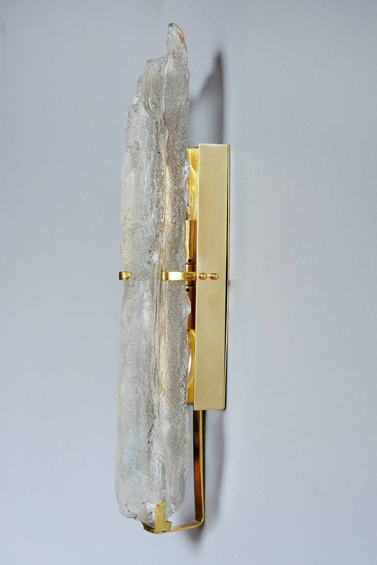 The glass TOTEM sconce captures the ineffable beauty of icicles and crystal stalagmites, and creates a true focal point in any room, whether the lights are on or off. The pared-down brass fixture glows with a shiny patina for an extra touch of