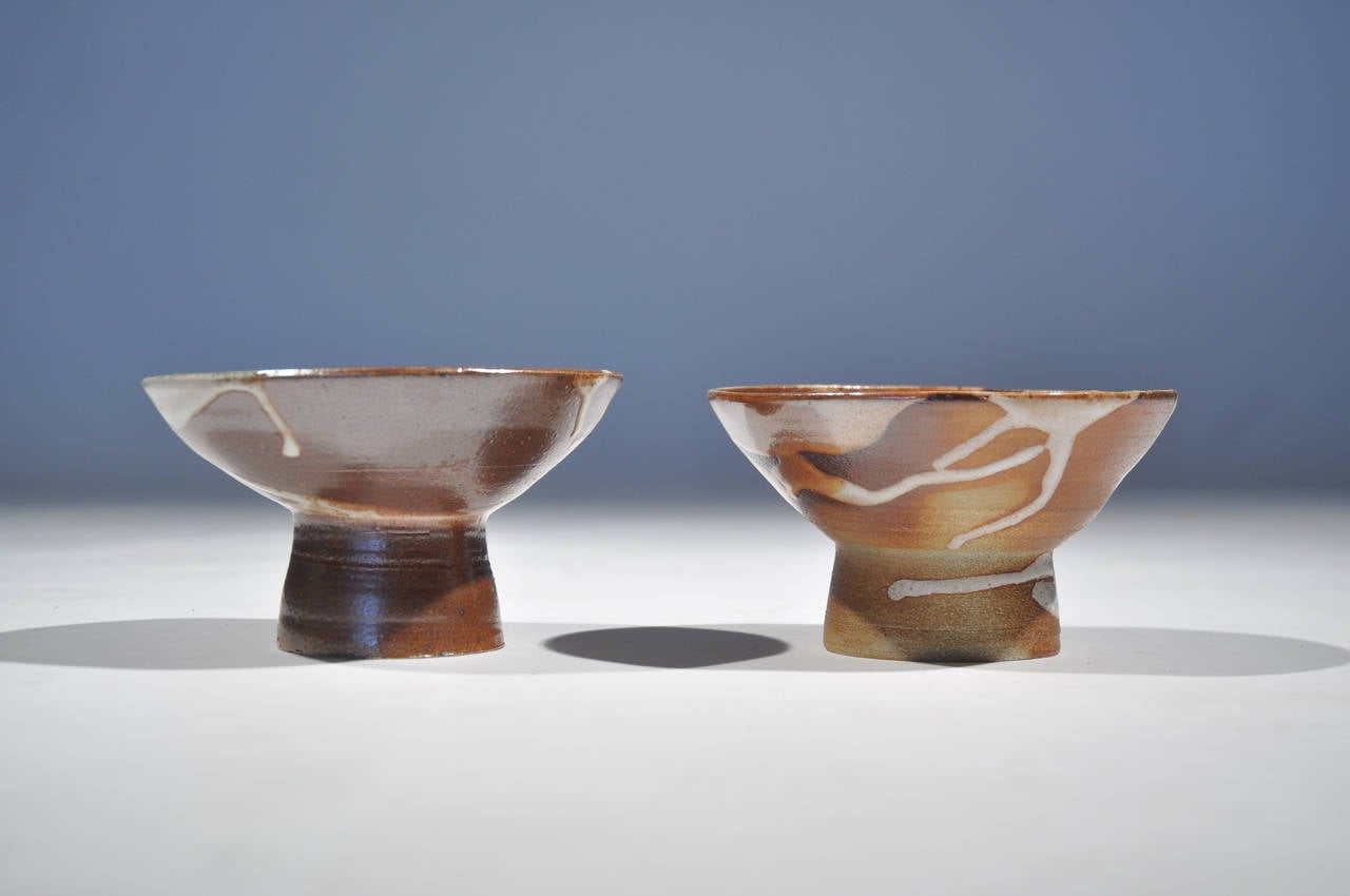 A pair of compotes in the Raku style.  They feature a rich, deep glaze with spiral accents, marked to bottom.

Dimensions: H 3.25