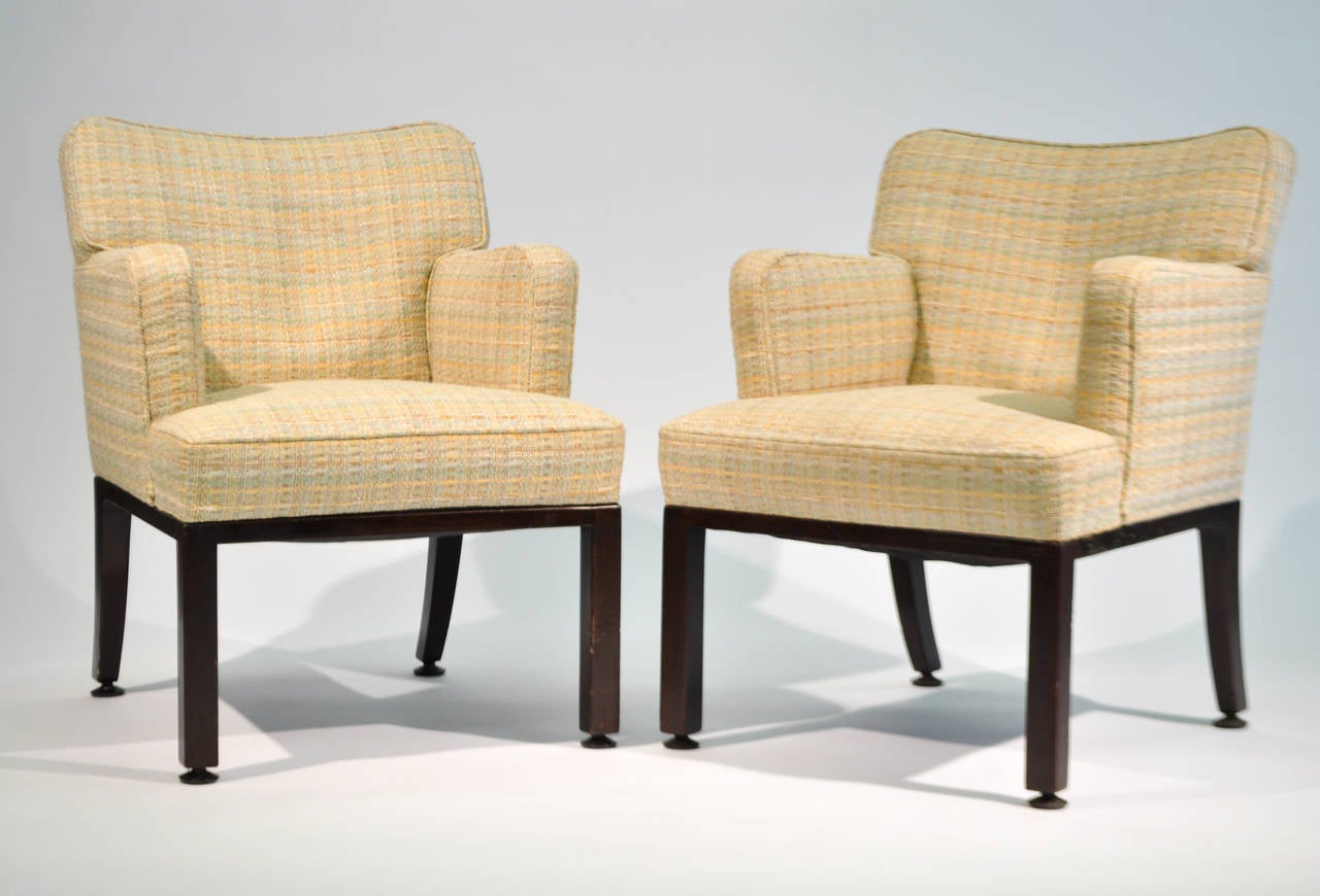 A beautiful set of tweed upholstered arm chairs by Edward Wormley, circa the 1950s.  The backrest features a graceful dip at the crest, over an elegant walnut frame with sharp, clean armrests.

Dimensions: H 32