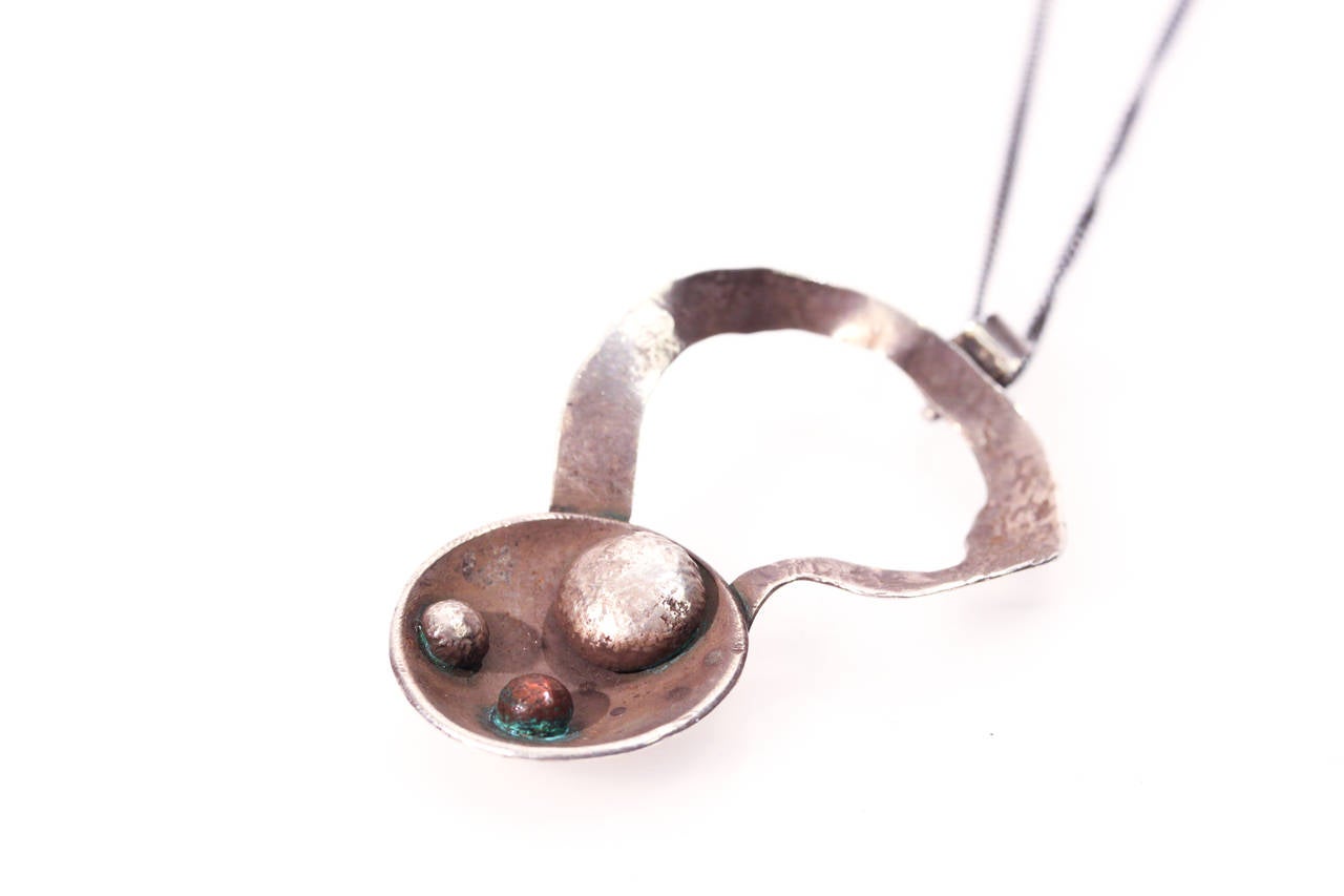 A beautiful David Smith art necklace, featuring sterling silver and copper.  This piece has a rounded pendant with asymmetrical dots.

Dimensions: H 2.2