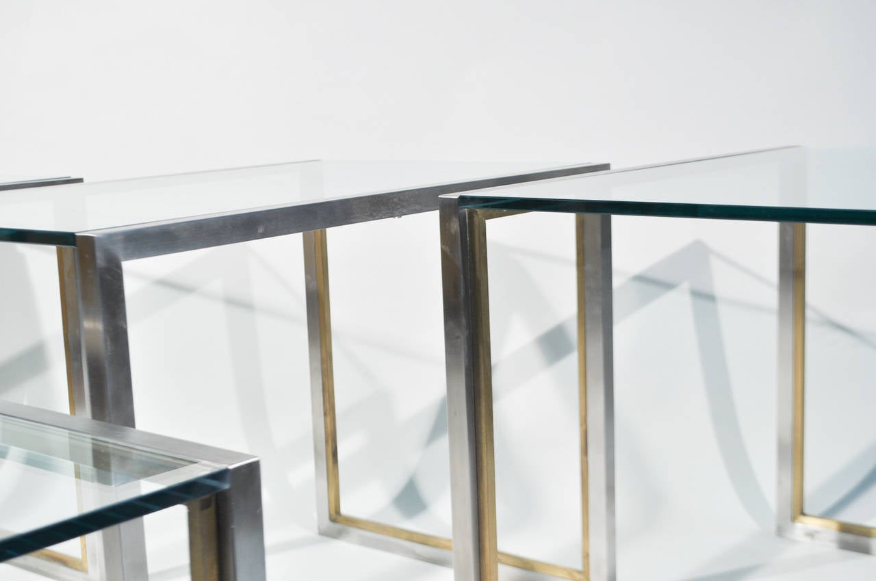 A beautiful set of four end tables, one of which can nest into the others. They feature a brushed steel frame and brass accent. 

Dimensions: Large: H 22