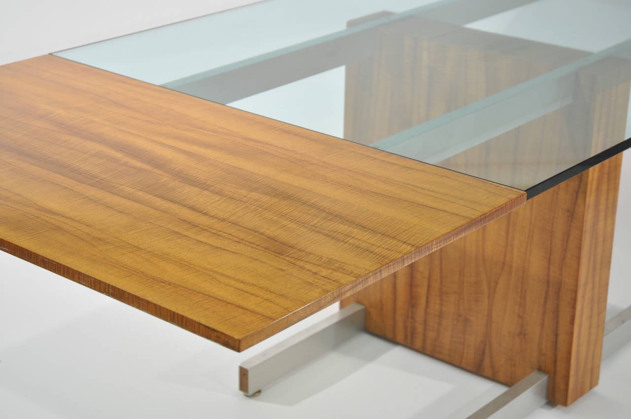 A beautiful example of rosewood, metal, and glass as they come together to form a breathtaking piece, circa 1960s. This piece has an unusually light rosewood veneer that was rarely used for this form. Furthermore, the veneer possesses curly wood,
