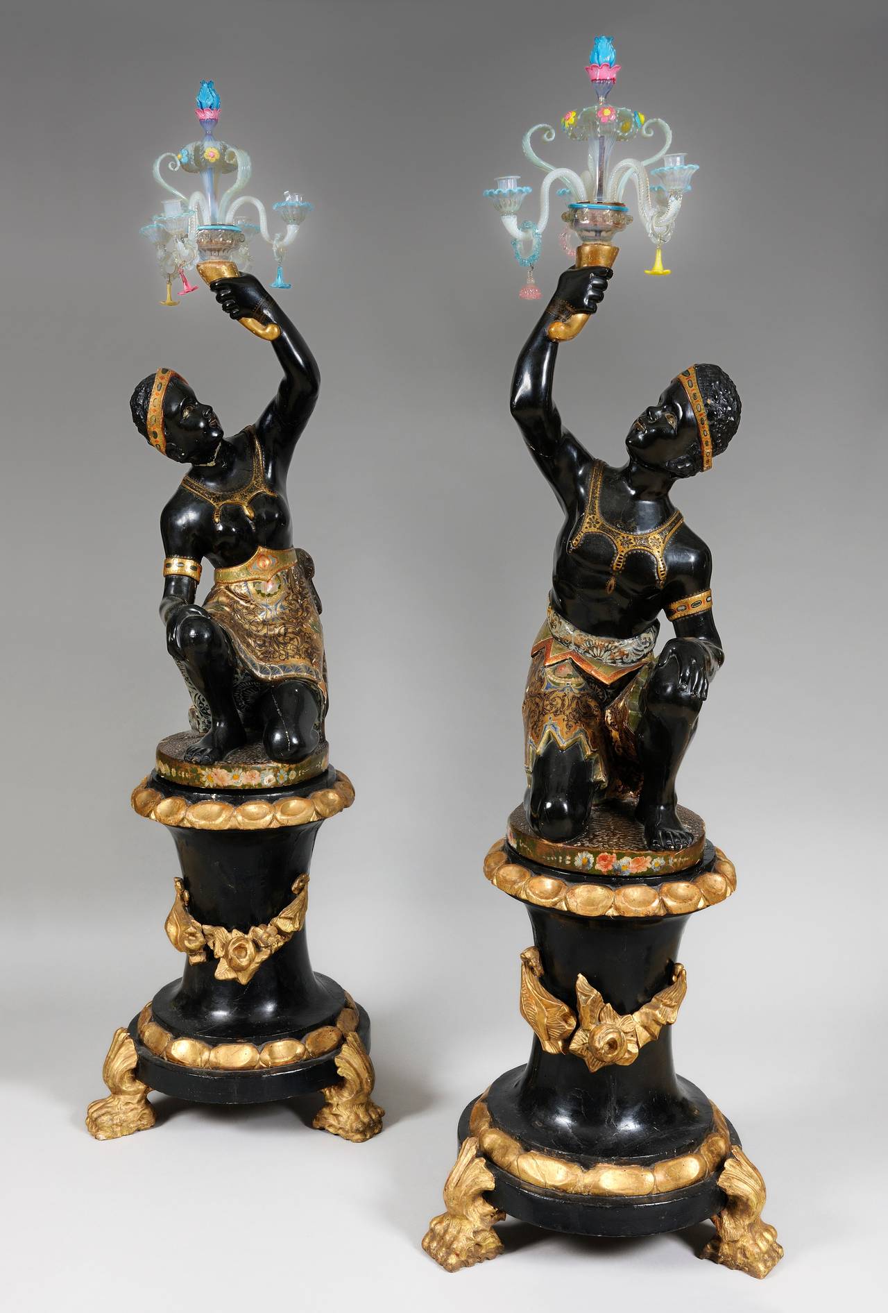 Pair of Venetian Nubian torcheres in painted and gilded wood with girandoles in Murano glass.

Italian work from the beginning of the 19th century.