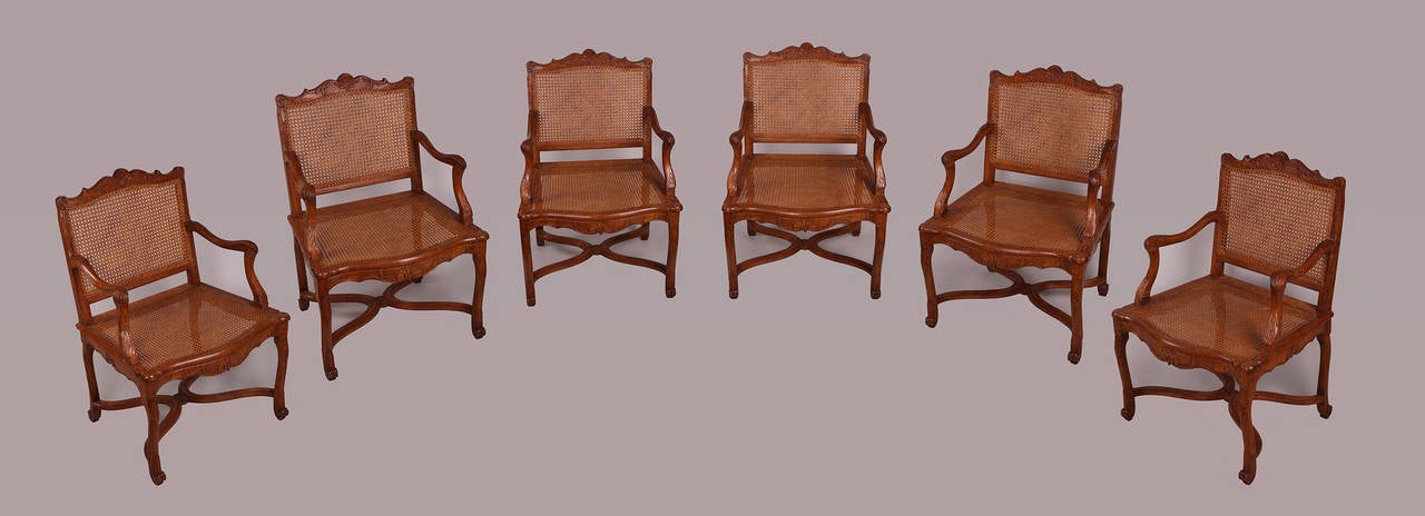 Suite of Four caned French Regence armchairs in walnut sculpted of acanthus leaves, shell and geometric patterns.

Parisian work form the Regency period.

Can be separated.
