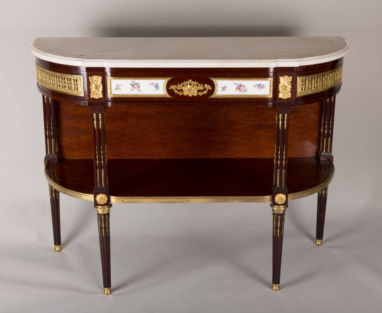 This exceptional console in satin wood with lattice pattern opens with one large central drawers covered with Sèvres plate and ormolu and two swinging side drawers.

The four legs are in pilaster ornate with ormolu mantel bronze.

Work from the