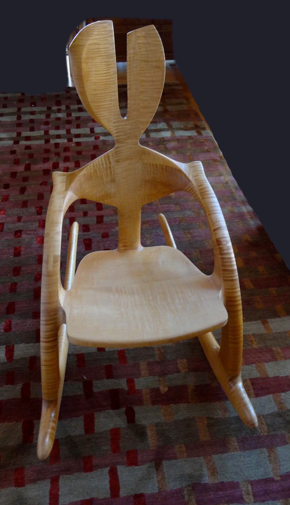 This Wendell Castle rocking chair is a unique variation on the Zephyr chair and is an excellent example of the artist's wit. The use of the beautifully figured solid tiger maple is also a rarity in Castle's seat furniture. The chair is constructed