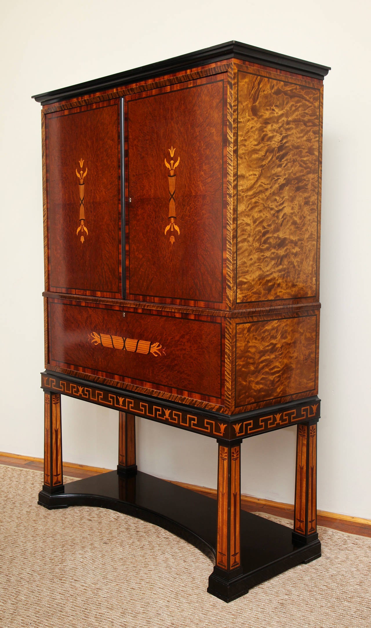 This cabinet is a stunning example of the modern classicism that led Swedish design in the 1920s and 1930s. Inlaid with vibrant timbers including birch, Macassar ebony and lemon wood and fitted with two cabinet doors with adjustable shelves over a
