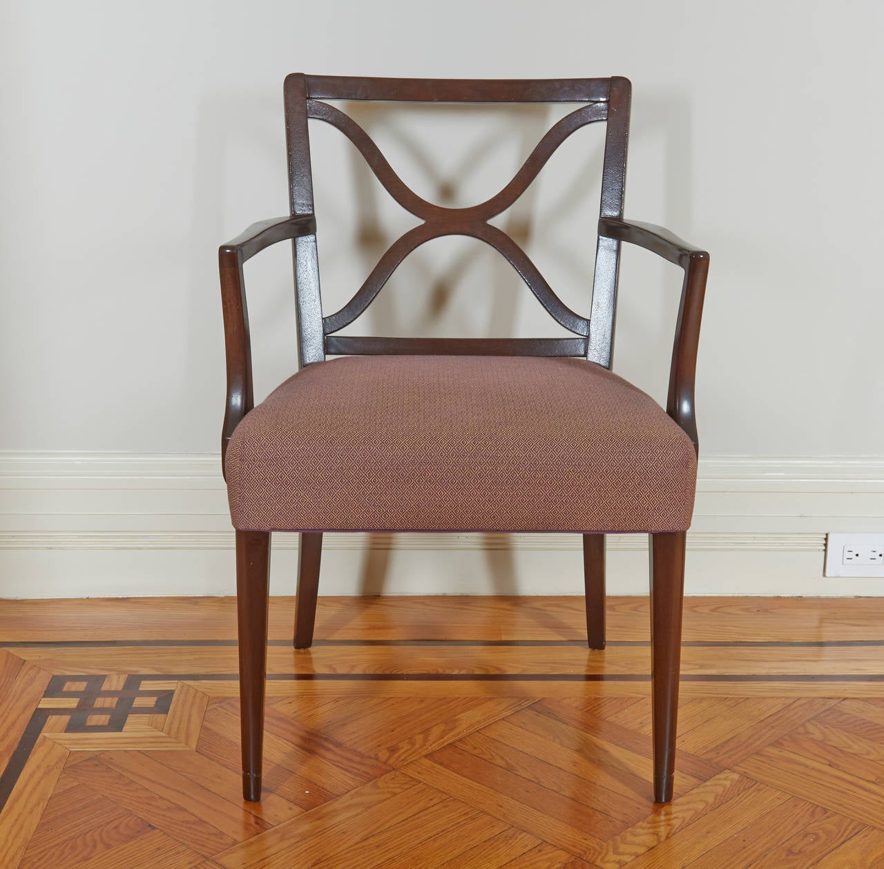 A modern interpretation of a neoclassical chair by one of the 20th century's foremost designers. 

Comprising two arm and six side chairs; each with square tapering back with X-form pierced back splat; the over-upholstered seats raised on square