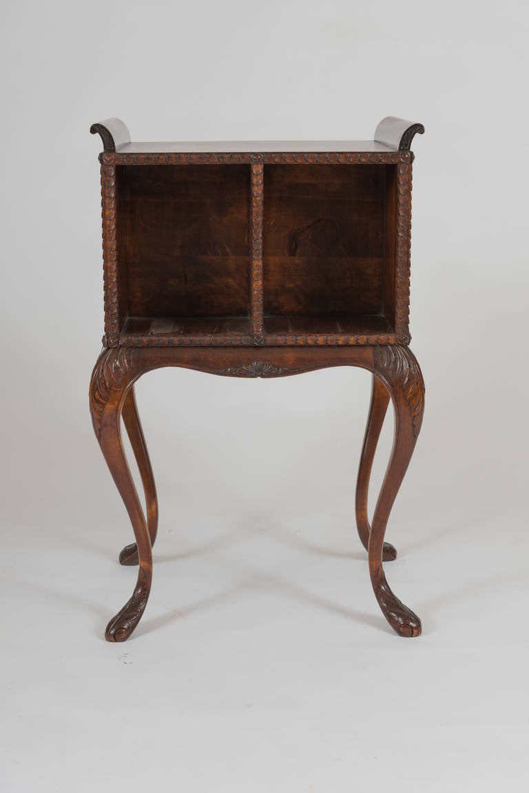The rectangular top with two outscrolled carrying handles, above a two-compartment well for books; raised on attenuated cabriole legs ending in foliate-carved pad feet. 

Provenance: Yale Burge Antiques.