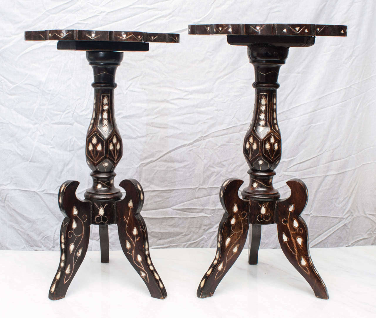 Chaque plateau en forme de tête de fleur est joliment incrusté d'une décoration florale stylisée ; sur un piédestal de forme balustre supportant trois pieds. Peut être vendu ensemble ou séparément.