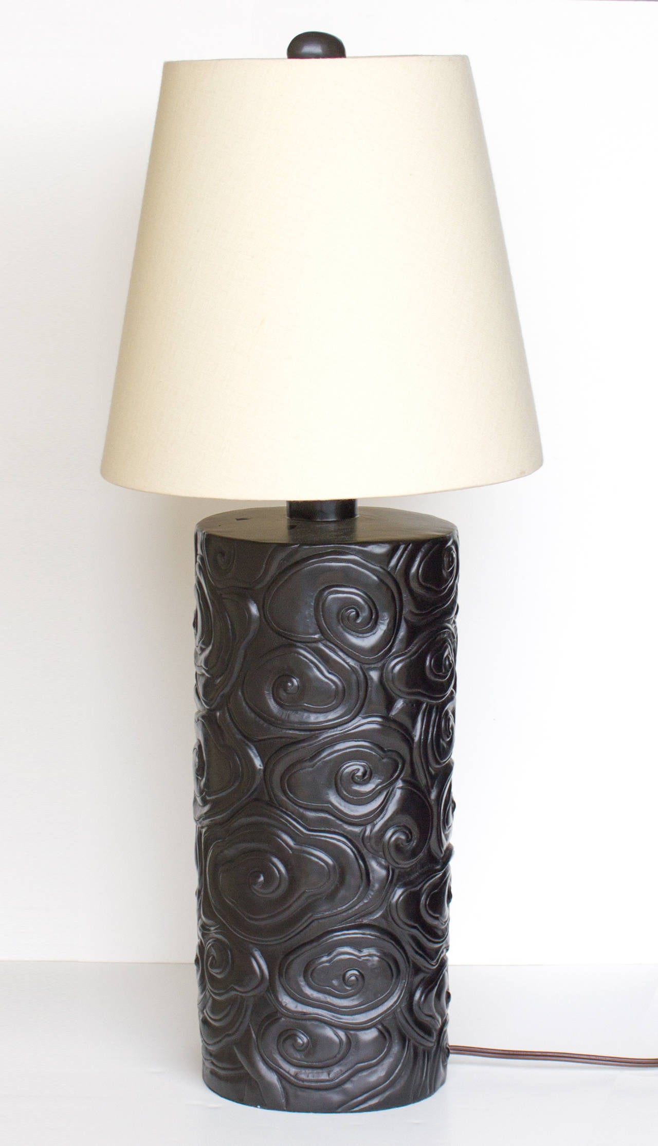 This Robert Kuo embossed lamp displays a stunning relief texture using copper repousse craftsmanship. The swirling clouds draw from traditional Chinese carving and art but the design invokes a contemporary feel. The black lacquer shade provides a