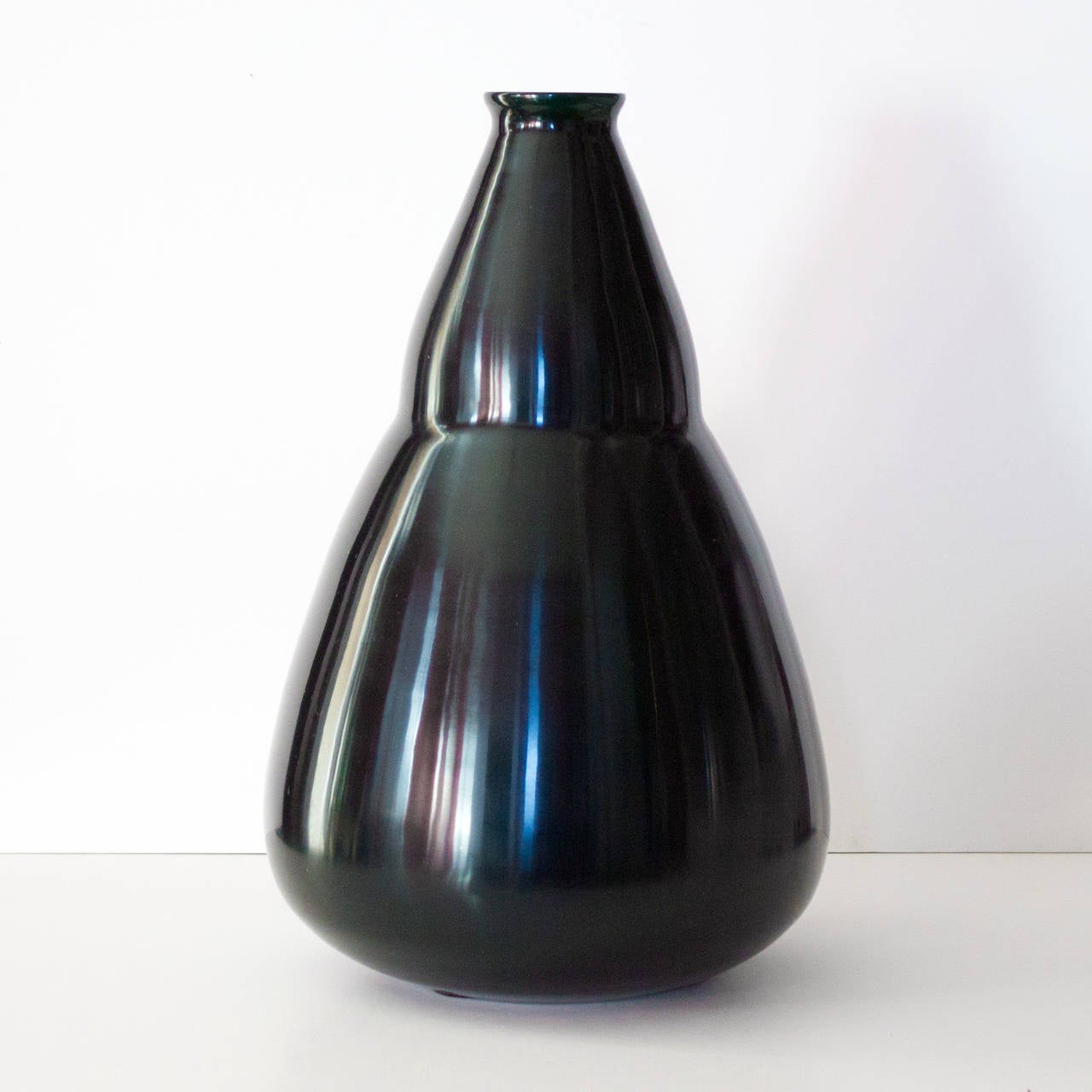 The Tourmaline Pear Shape Vase created by renowned artist Robert Kuo expressly combines earthy beauty with an organic form. Multiple layers of hand-blown glass create a luminous depth of color and a strong, graceful design. The ancient Chinese