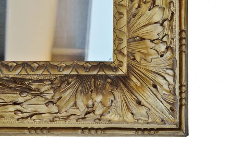Finely detailed French giltwood mirror, decorated with laurel leaves and berries around the rectangular frame.