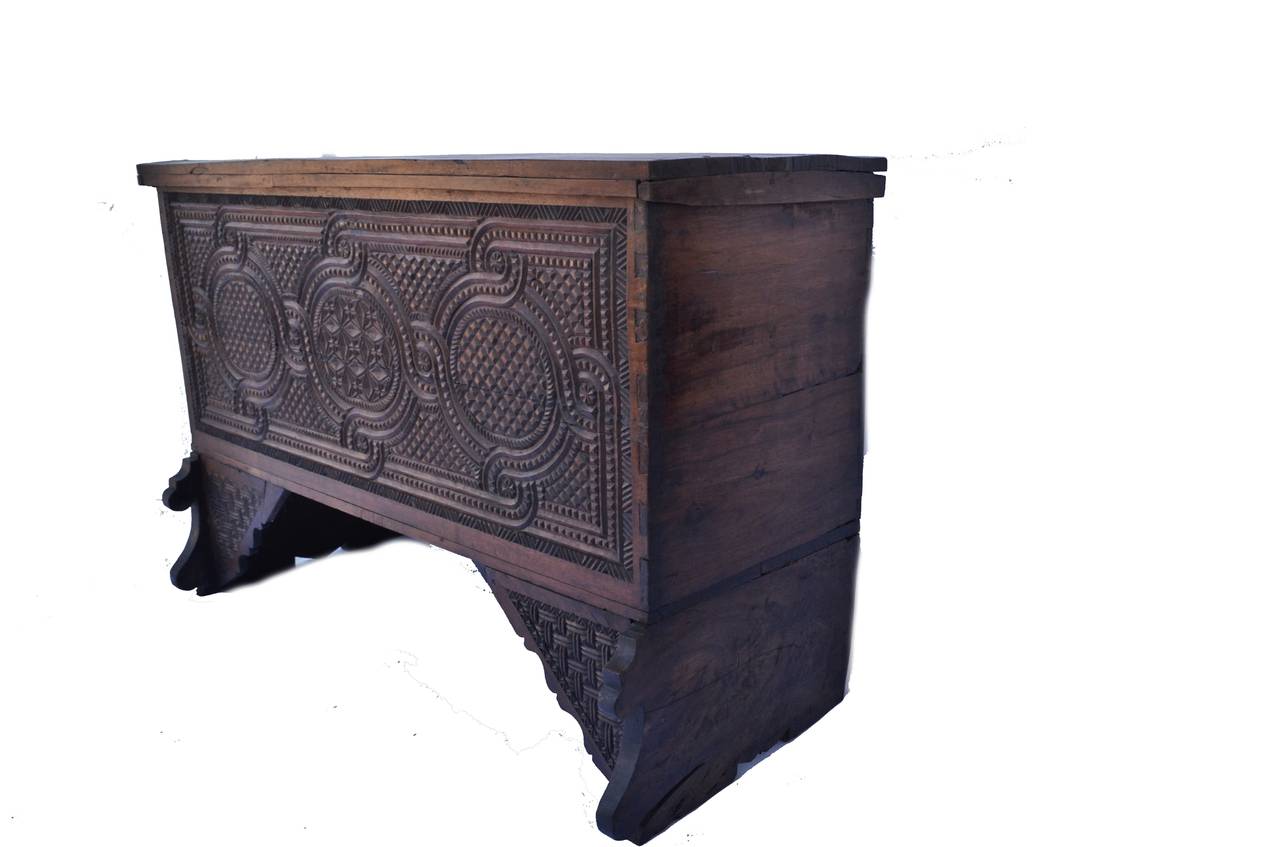 Large Spanish trunk or sideboard; a hinged top opening to the interior, the front with deep, profuse geometric relief carving, joinery includes large corner dovetailing.