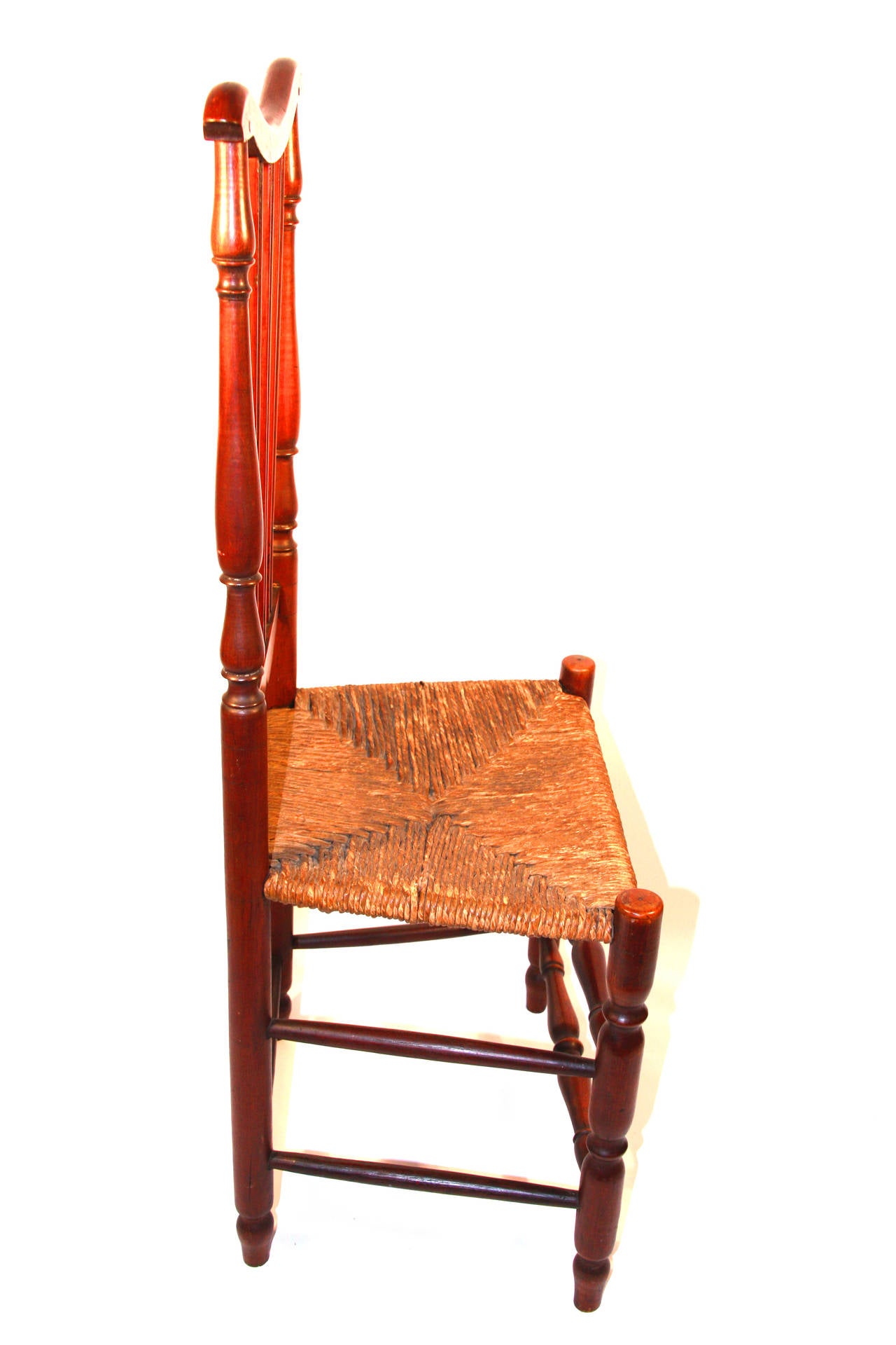 Pair of maple and ash or oak banister-back side chairs, the seat frame tenoned directly into the front legs which extend upward beyond the rush street.  Rear posts composed of  series of three stacked baluster turnings of different sizes above a
