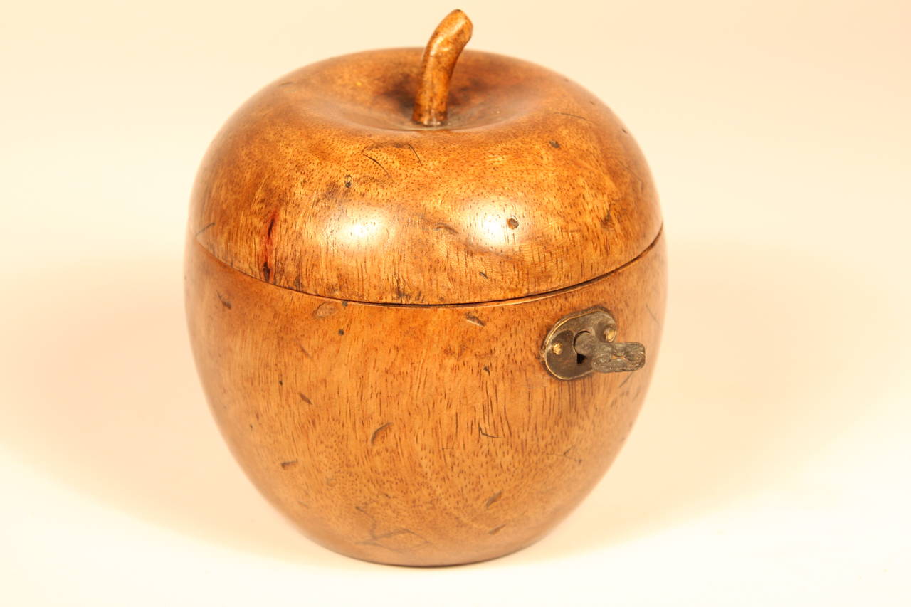 Early 19th century fruitwood carved apple tea caddy with carved stem, original locking mechanism, and key. Lined with tin paper. Fine patina.