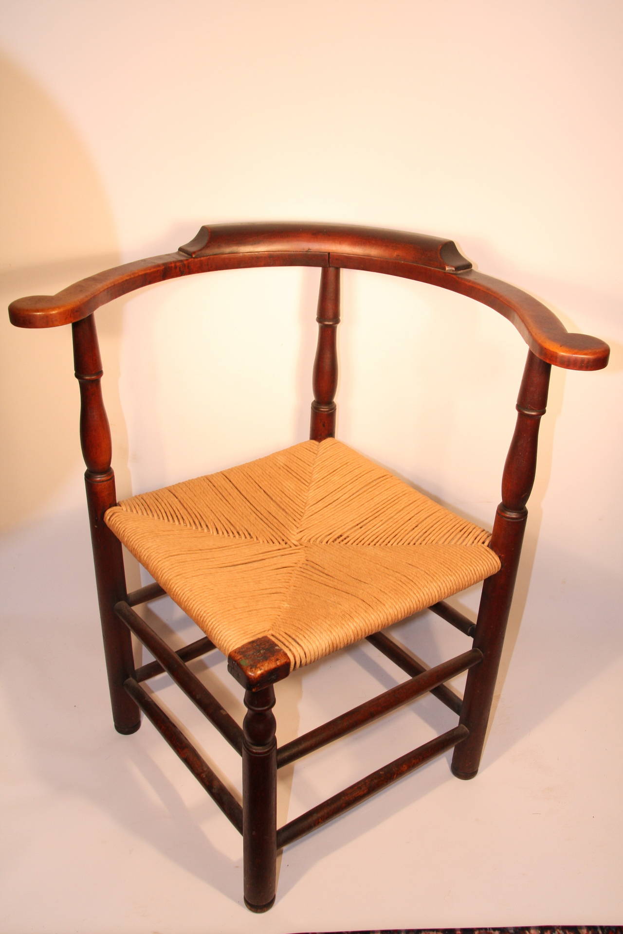 Country turned maple roundabout chair, New England, late 18th century, the round back with scrolled handles with a woven rush seat on turned legs and stretcher base.

Measures: 24