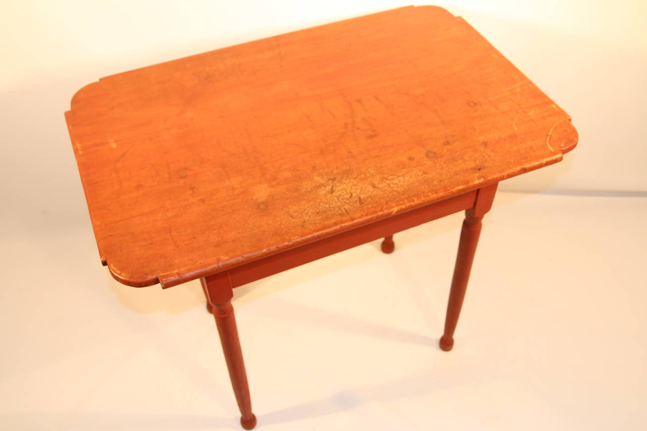 Transitional Queen Anne tap table with ovolo corners and pegged one board top attached to base with turned legs ending in bun feet.  Old red paint on tabletop with newer paint on base.

New England, Circa 1780.

27”H x 32 ¾”L x 21 ¾”D.