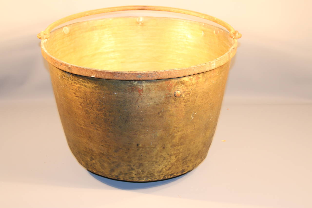 Pennsylvania brass apple butter cauldron with hand forged iron handle, circa 1840. All original with scratches and dents consistent with age and use.

Great architectural element for indoor or outdoor use.

Measures: 13