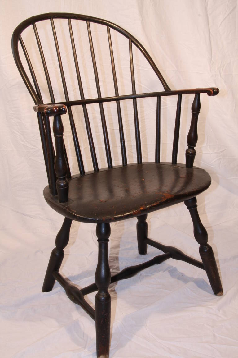 Fine sack-back knuckle arm windsor chair comprised of pine, maple, hickory and ash. Well developed form with arched round crest raked rail terminating in square ends (typical of North Central Connecticut) above seven spindles joined to the medial