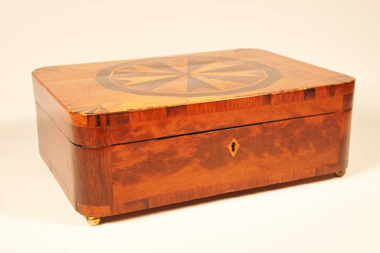 FIne mid-19th century mahogany box with rounded corners and heavily inlaid top having fitted interior with seven compartments, the cover to the center compartment inlaid with ebony, birds eye maple, and burl wood, the other six lids birds eye maple.