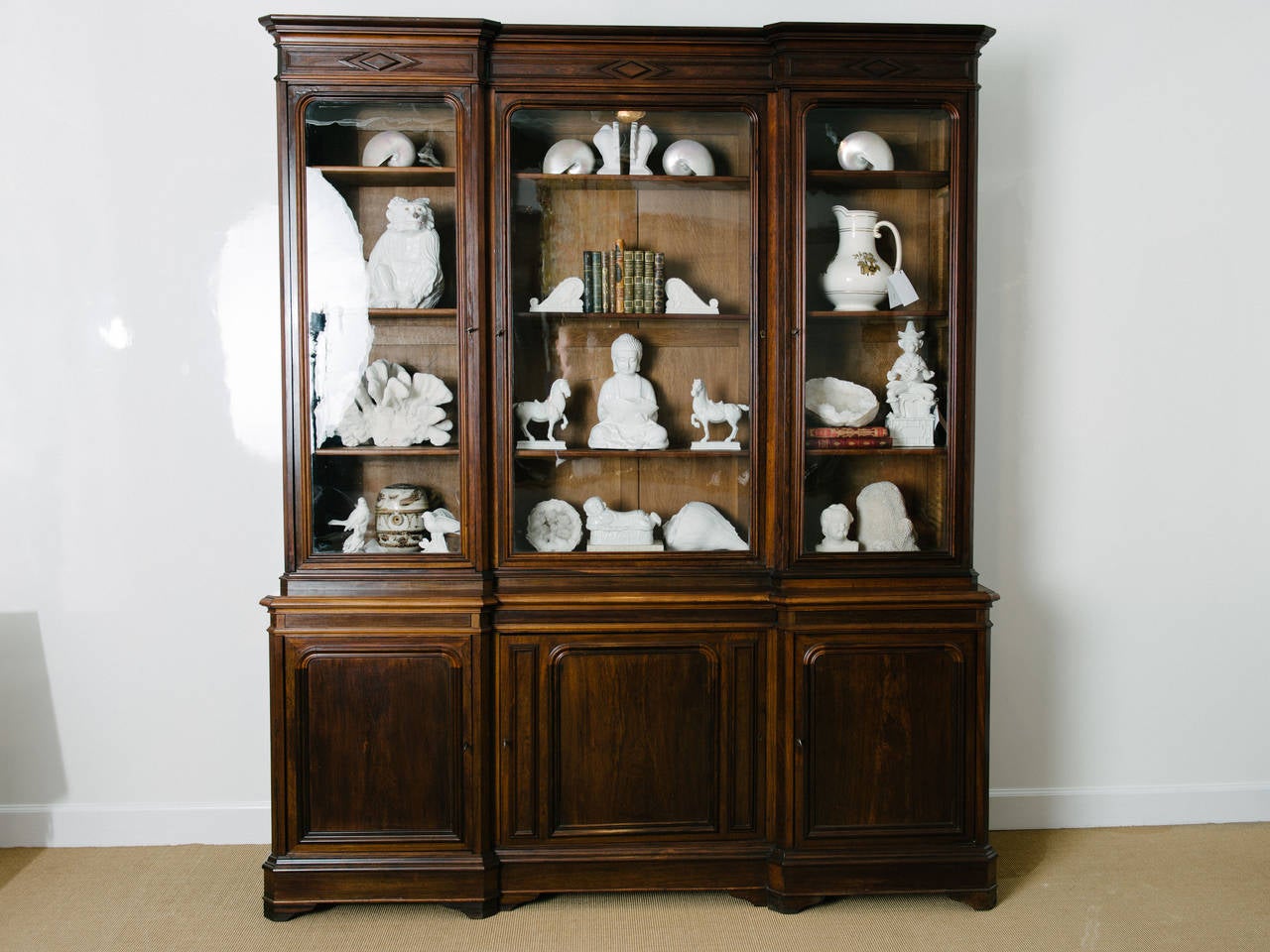 Beautiful French Louis Philippe walnut bookcase with three glass doors above three storage cabinets below.