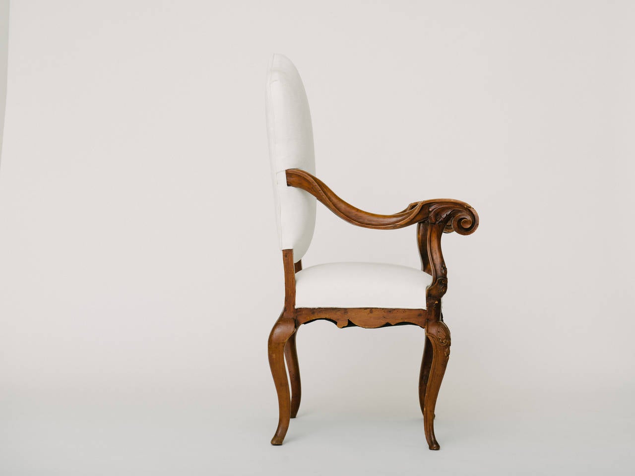 18th century French fauteuil with beautifully carved scroll arms and shell detail. Newly upholstered in crisp white.