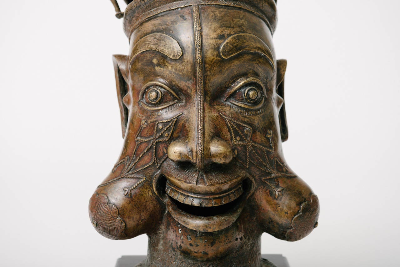 A 20th century decorative African style bronze head mounted on wood base of the Tikar people in Cameroon.
  