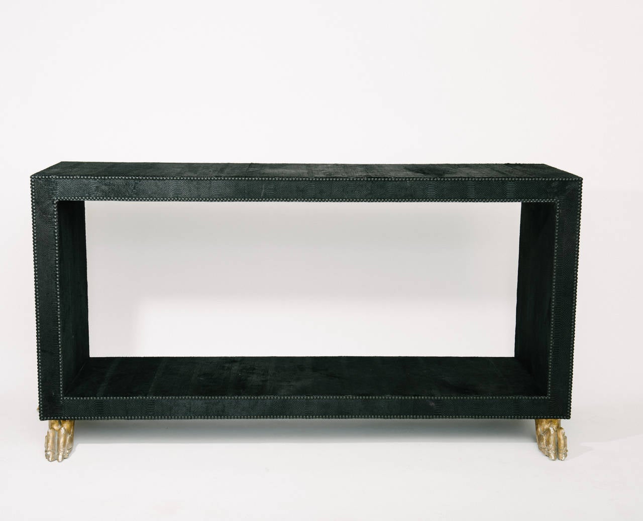 An avant-garde custom Parsons console wrapped in a jet black Italian laser etched snakeskin hair hide with matte black nailhead detailing. This unique Silhouette sits atop four carved giltwood lion's feet in the manner of Jean-Charles Moreux. Also