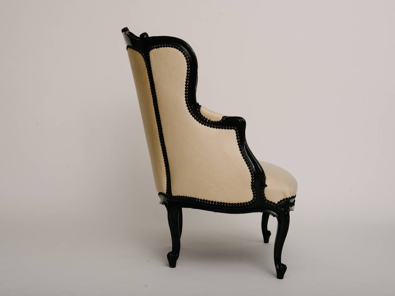 19th century black lacquered bergère. Newly upholstered in a nude Italian leather and matte black nailhead trim.