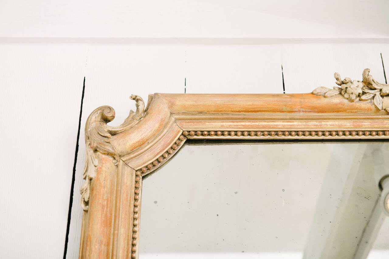 Italian giltwood full length mirror with three-leaf embellishment.