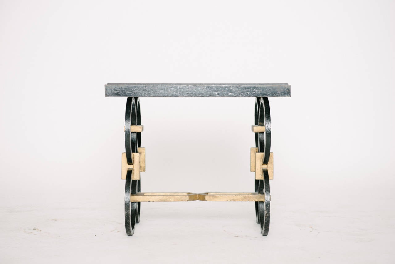 Vintage French occasional table with hand-forged patinated and gilt iron base and black stone top.