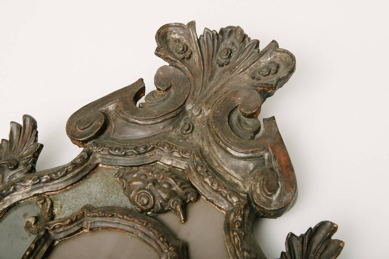 A rare pair of 18th century Venetian silver-gilt carved wood mirrors with original glass.