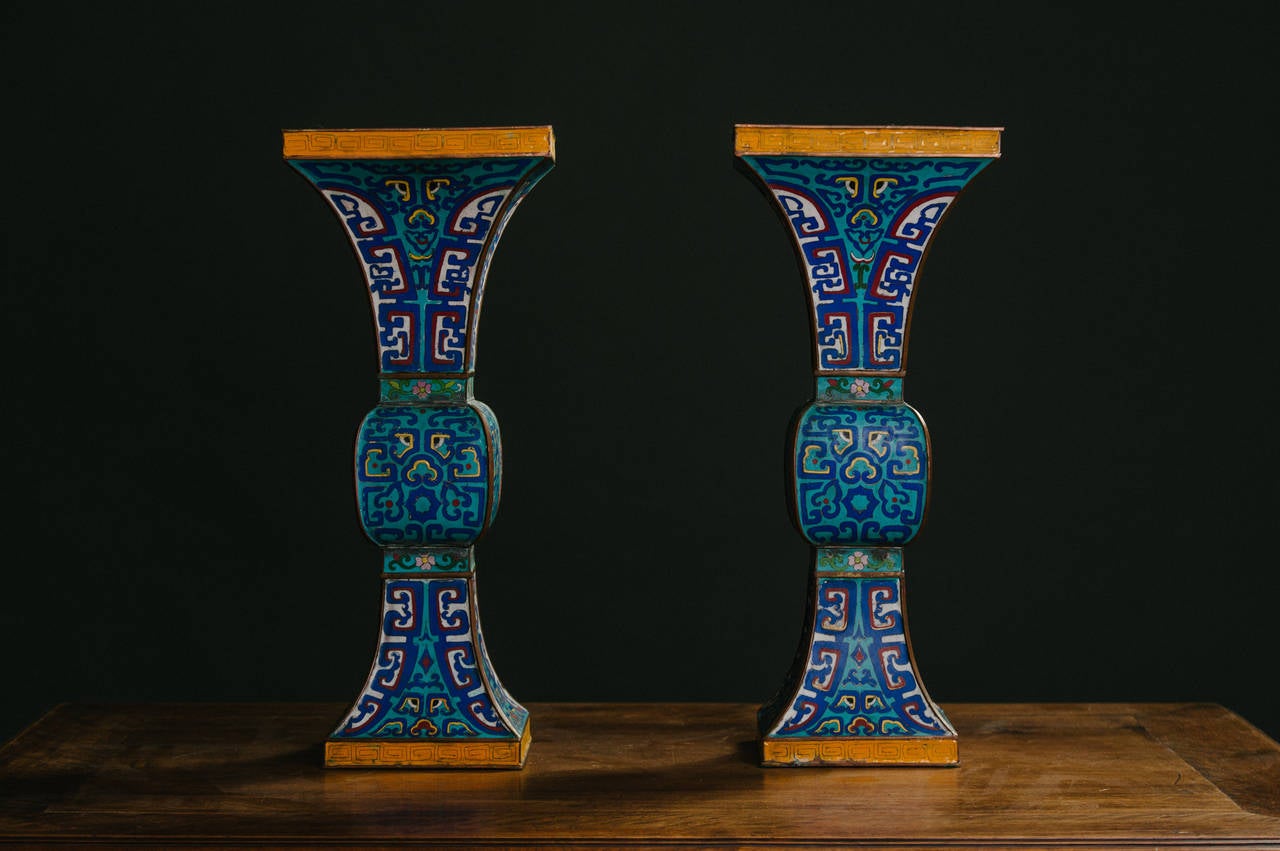 Pair of stylish mid-19th century Ming style cloisonné with beautiful gold gilt Greek key detail.

Chinese cloisonné objects were intended primarily for the furnishing of temples and palaces, because their flamboyant splendor was considered