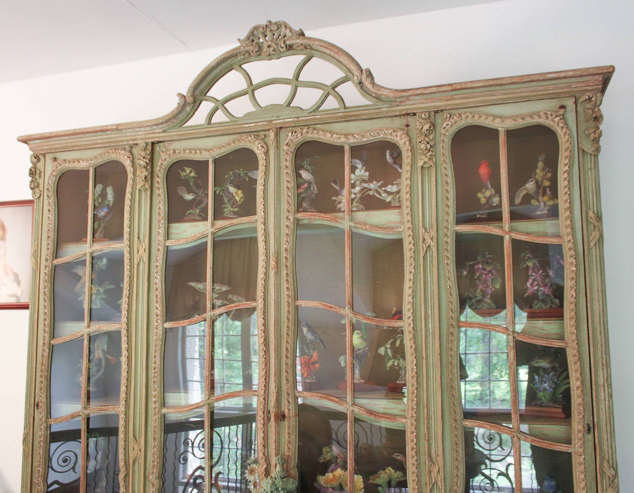 Exceptional French hand-carved and painted 4 door display case.  Beautifully carved in floral and ribbon motif.  Having an aged painted finish that offers rich character and charm. A classic of heirloom quality and craftsmanship!