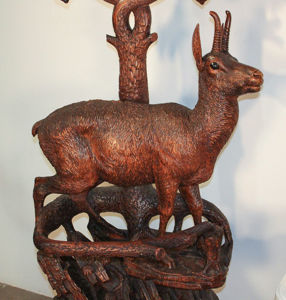Magnificent rare Swiss Black Forest carved deer form hall stand with mirror. Having impeccably detailed deer and eagle carvings above rock form base and tree branches with beveled mirror. Exhibiting a time worn patina that offers rich character and