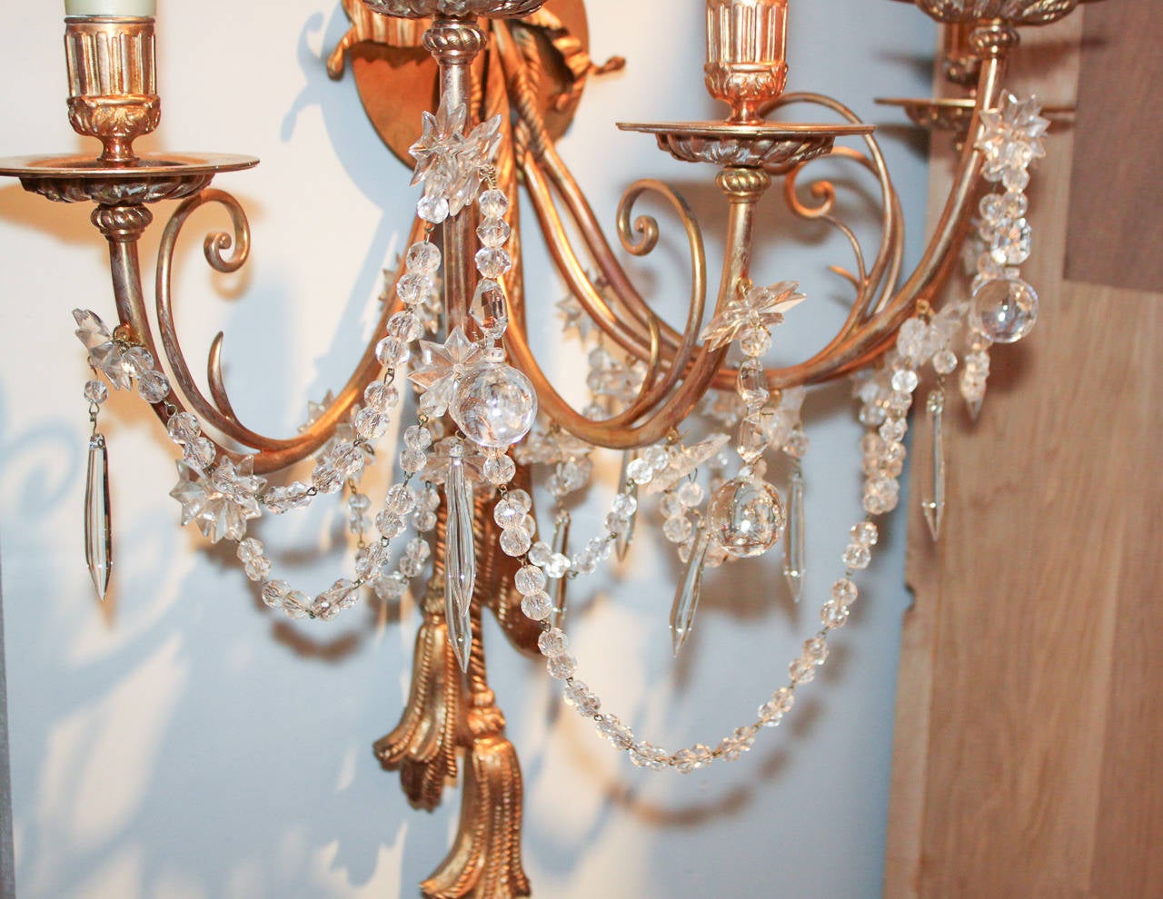 Elegant pair of French gilt bronze and crystal 5-light wall sconces.  Having gilt bronze ribbon and tassel motif, and gracefully curved arms adorned with drop prisms and beaded strands.  