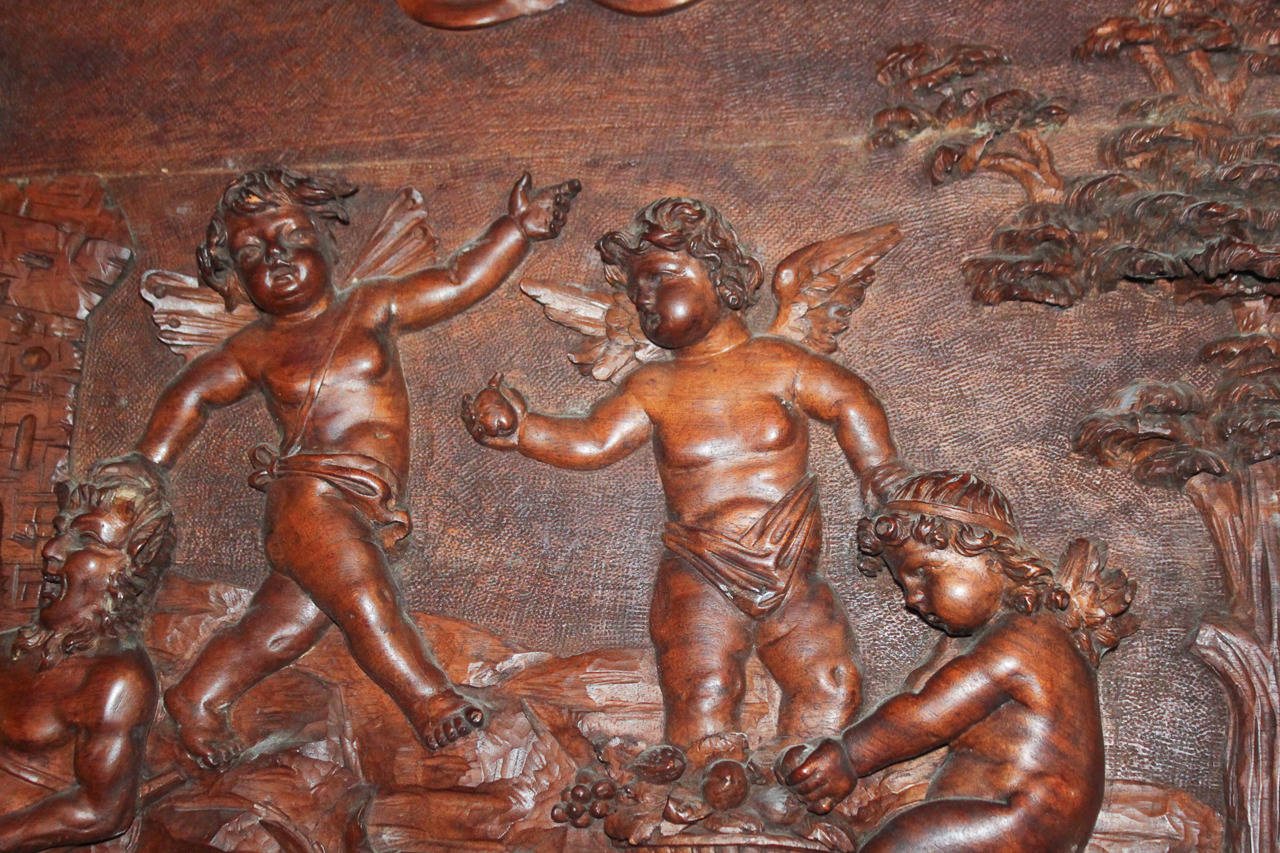 Exceptional French hand-carved walnut panel depicting the struggle between Cupid and the Greek god Pan.  Magnificently detailed carving portrays the triumph of love over carnal lust which illustrates Virgil's quote, 