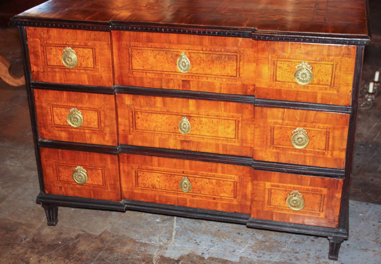 Fantastic South German walnut inlaid three-drawer commode. Having amboyna burl inlays on all sides and across drawer-fronts, bronze hardware, ebonized trim and an inverted breakfront. Exhibiting a beautiful patina and clean lines that work in