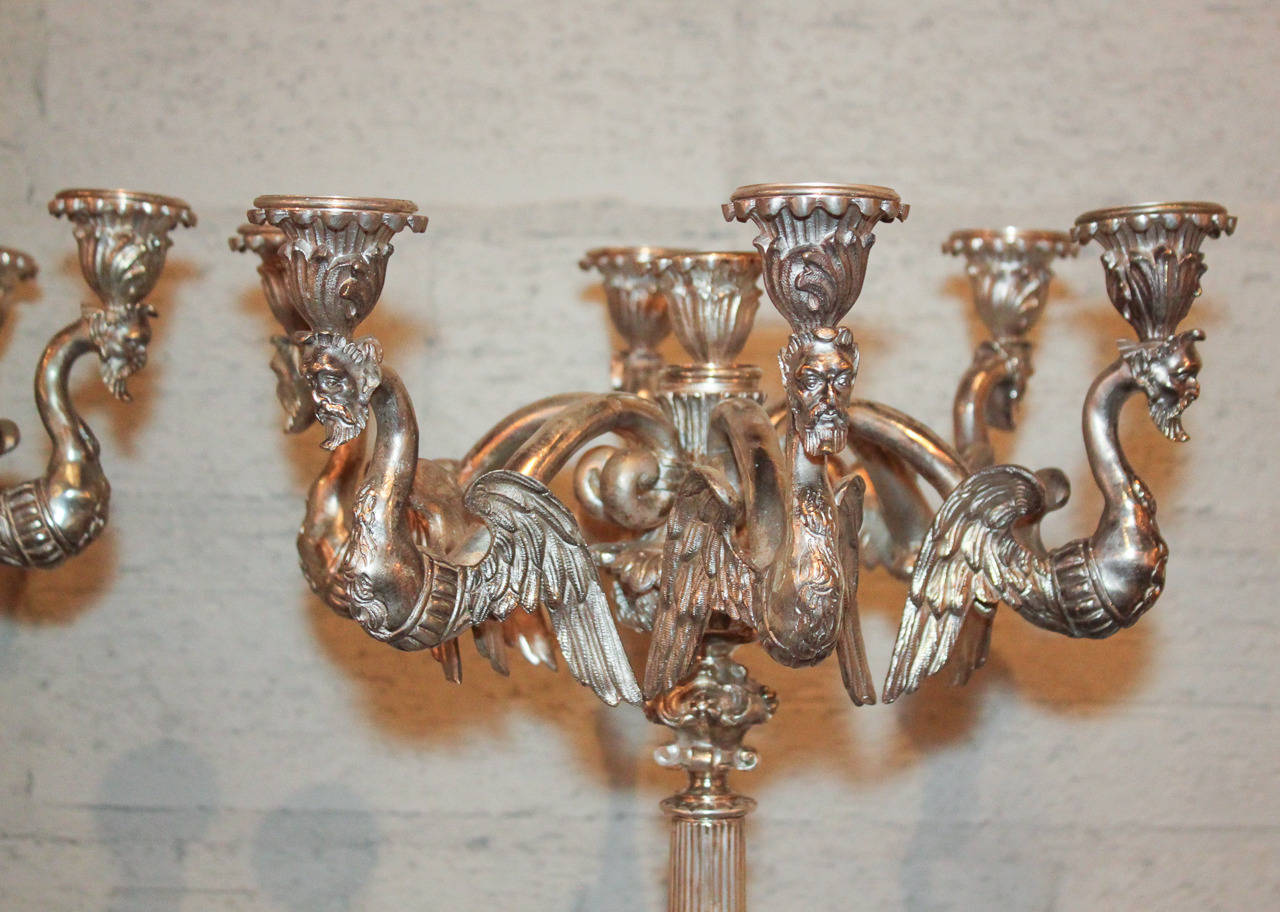 Sensational pair of Continental silvered bronze 7-candle candelabra with detailed castings.  Having figural arms in Greek siren form, a fluted support, and resting on a figural support base with claw feet.  Exhibiting a beautiful finish and classic