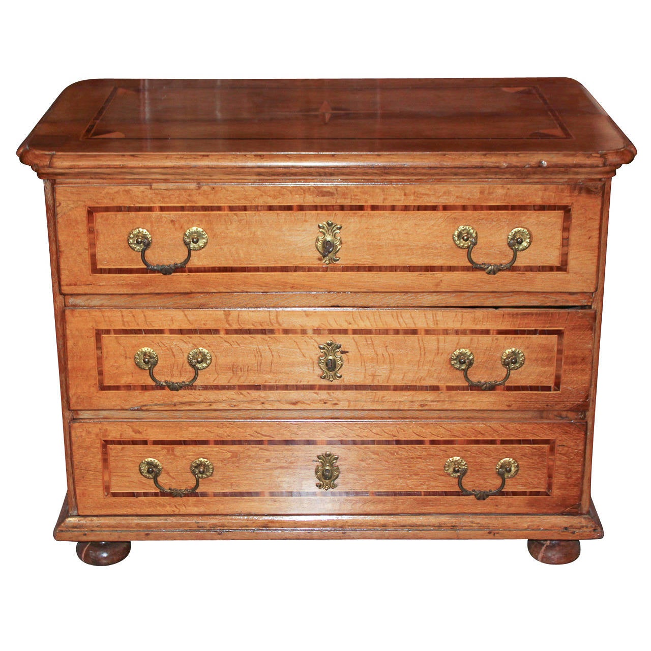 Sensational German oak 3-drawer commode. Having lovely inlays on all sides of piece and each drawer front. With gilt bronze hardware and resting on bunn feet.