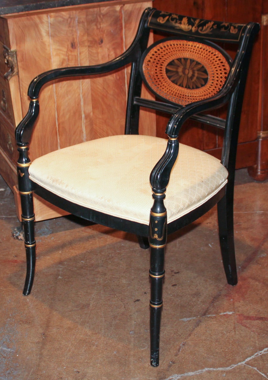 Excellent set of custom Regency style armchairs in ebonized wood. Having oval cane insert in back and adorned with floral and leaf motif.  Featuring crisp lines that would complement any decor!