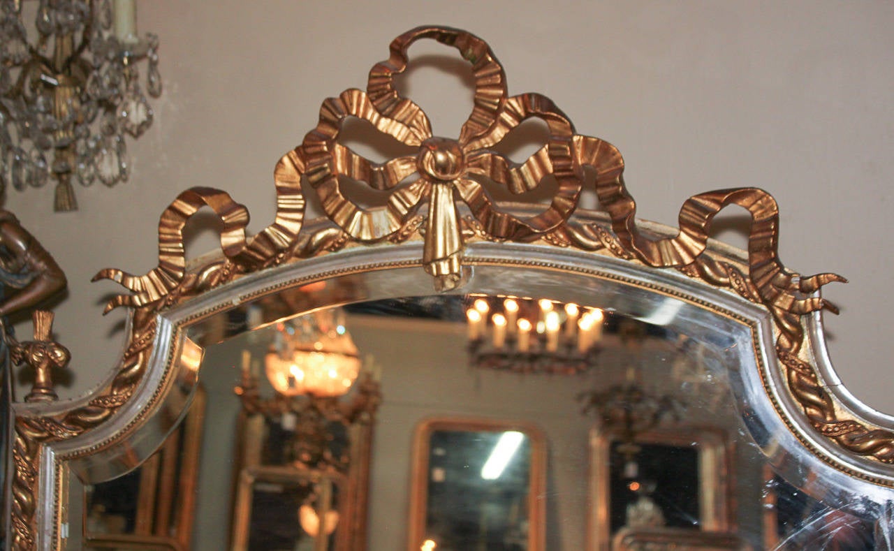 Gorgeous silver and gold giltwood French Louis XV style mirror. Having ribbon form cartouche, beaded heavy rope design along frame and acanthus leaf accents. Ready for your designer touch!