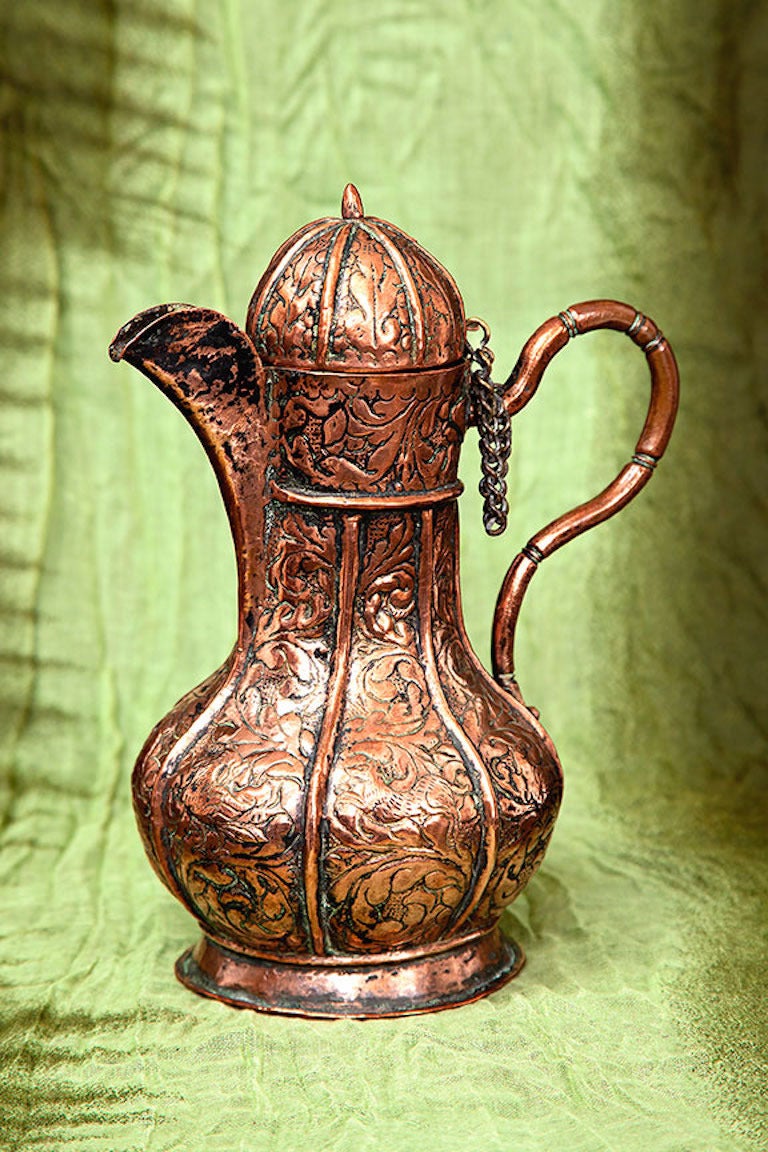 A rare 16th Century Venetian Copper Ewer; approx 8 inches tall; the vertical side panels are intricately chased with birds and hunting dogs surrounded by foliate decoration; the style of the piece is clear evidence of the close links between Venice