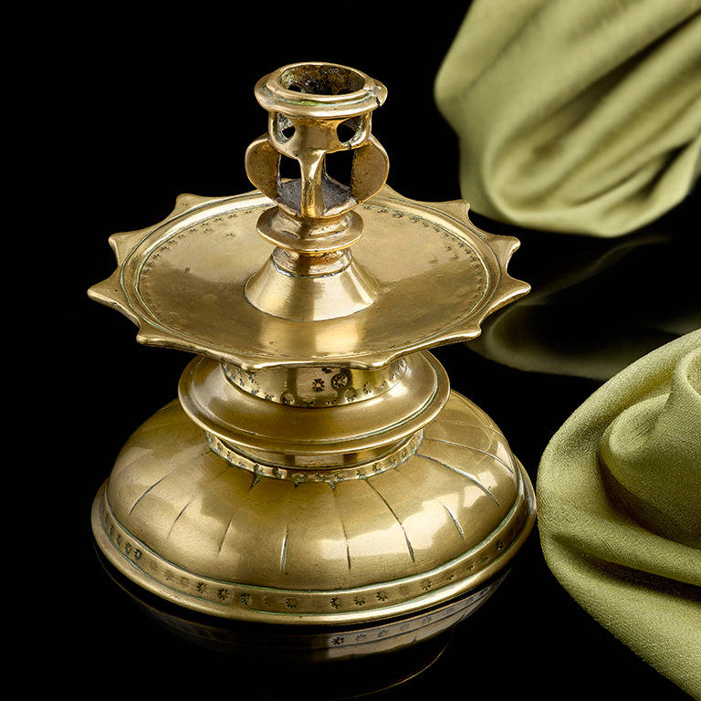 A very rare late 16th century brass candlestick; Spanish x. 1580; the 'Moorish' influence in the design is clear, particularly the 12 pointed drip pan which is based on earlier Islamic examples; the number 12 is of particular significance in the