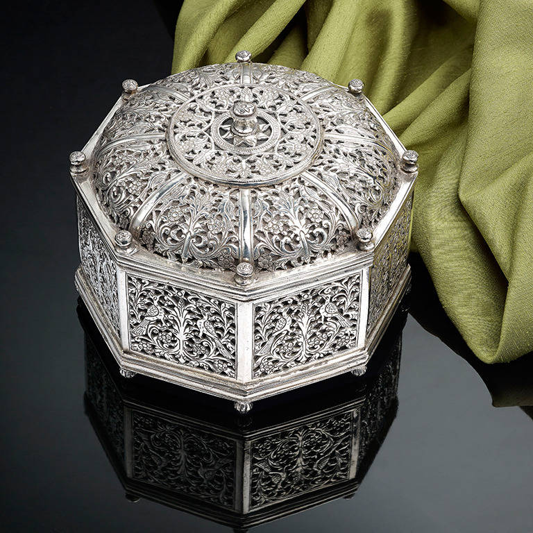 A Very Rare Indo - Portuguese Silver Octagonal Box; Goan; 17th Century; profuse pierced decoration with floral motives and exotic birds; approx 5 inches in height and 6 1/4 inches in diameter; the weight 24ozs approx.
This piece was included in an
